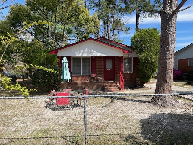 bungalow with fence and brick siding