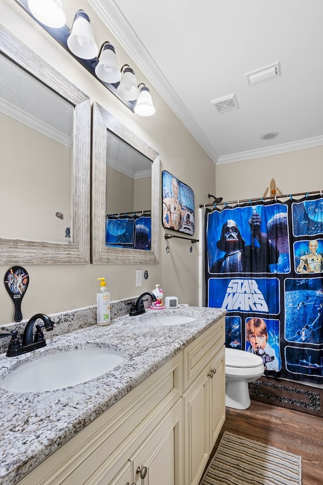 bathroom featuring hardwood / wood-style floors, vanity, toilet, and ornamental molding