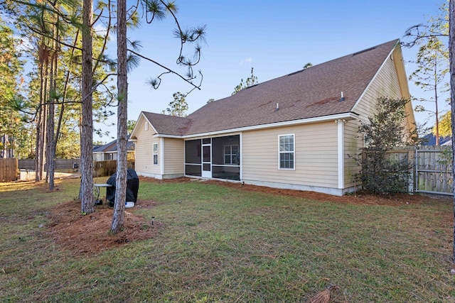 rear view of property featuring a lawn and a sunroom