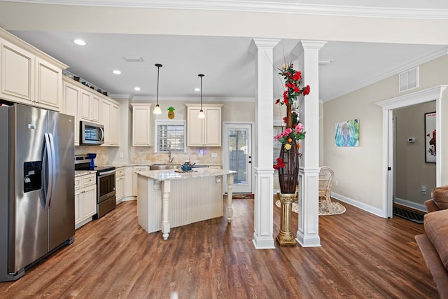 kitchen with appliances with stainless steel finishes, dark hardwood / wood-style floors, crown molding, and pendant lighting