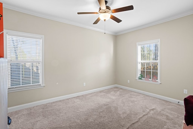 carpeted spare room featuring crown molding and ceiling fan