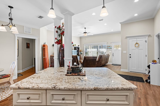 kitchen featuring wood-type flooring, ceiling fan, and pendant lighting