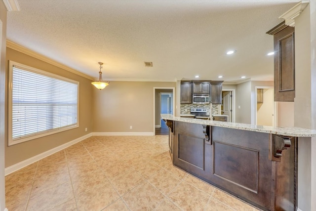 kitchen featuring pendant lighting, stainless steel appliances, tasteful backsplash, light stone counters, and dark brown cabinetry