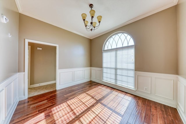 unfurnished room with ornamental molding, a chandelier, and wood-type flooring