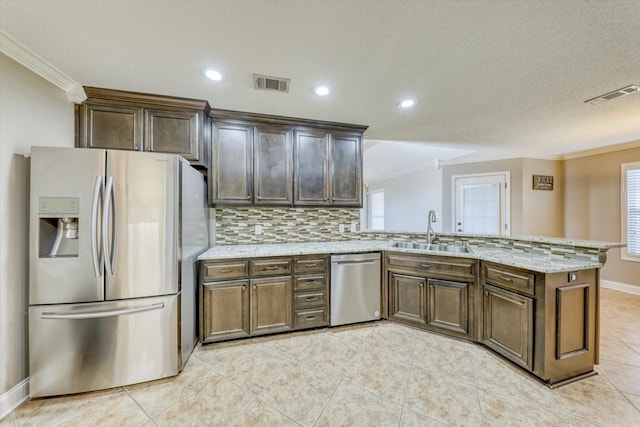 kitchen with light tile patterned flooring, tasteful backsplash, sink, light stone counters, and stainless steel appliances