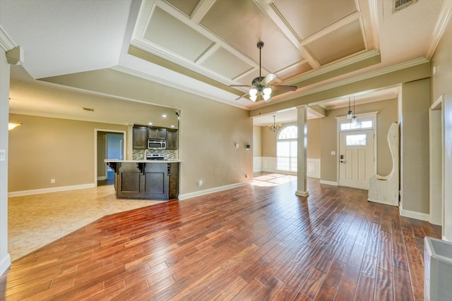 unfurnished living room with coffered ceiling, hardwood / wood-style flooring, ceiling fan with notable chandelier, and ornamental molding