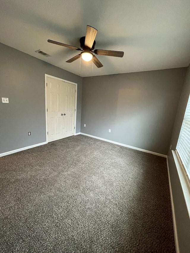 unfurnished bedroom with a closet, baseboards, visible vents, and ceiling fan