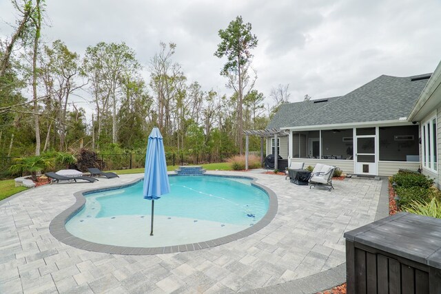 view of swimming pool with a sunroom and a patio