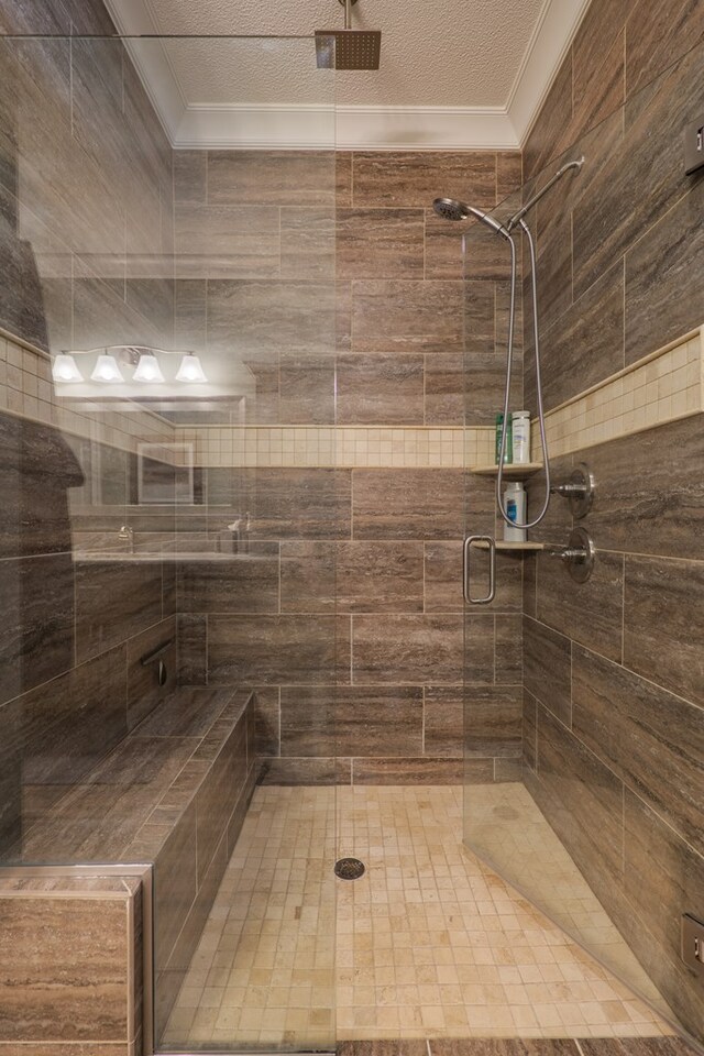 bathroom featuring a shower with shower door, a textured ceiling, and ornamental molding