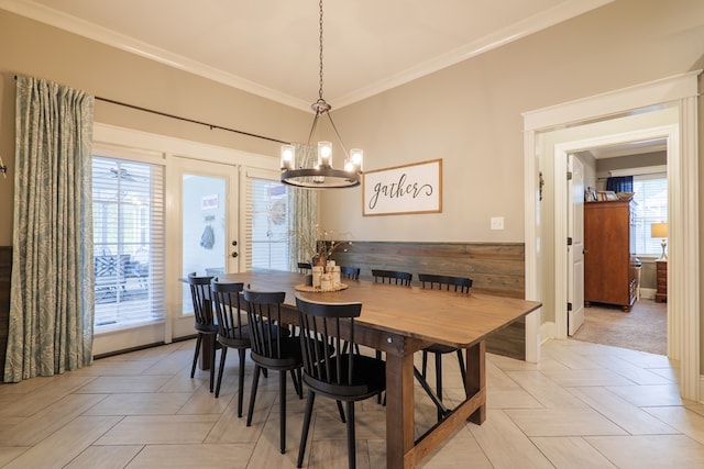 dining space with crown molding and a notable chandelier