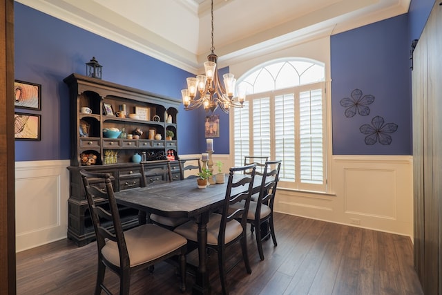 dining space featuring a tray ceiling, crown molding, dark wood-type flooring, and a notable chandelier