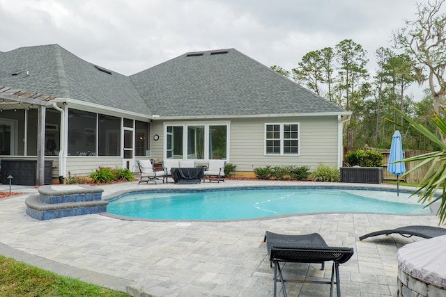 view of pool with a sunroom and a patio