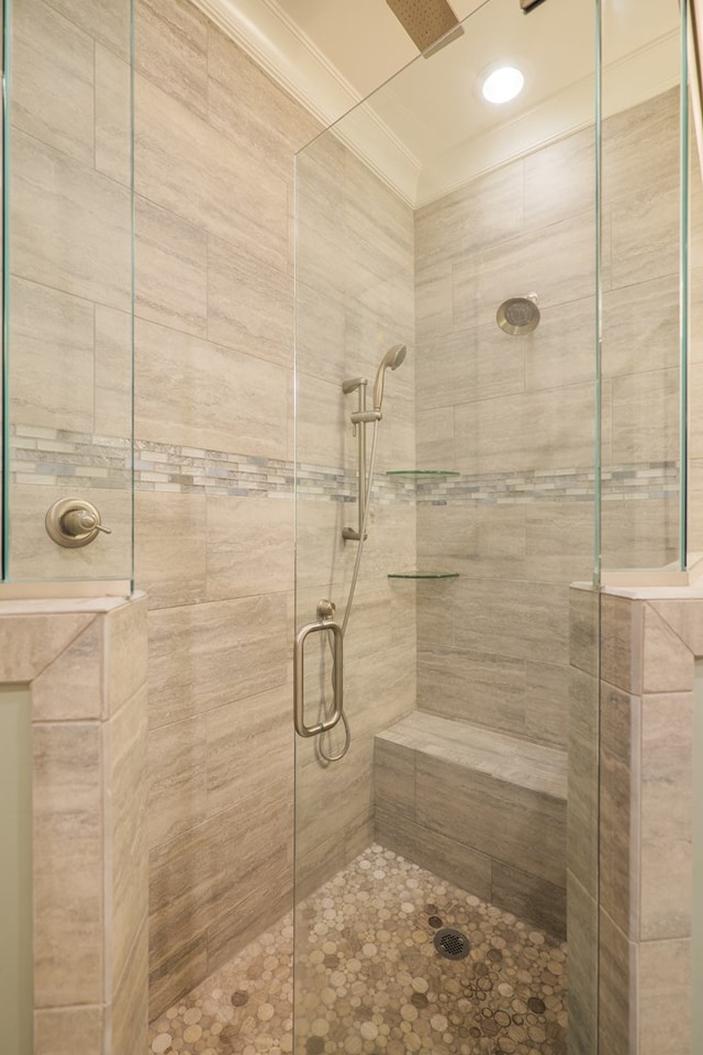 bathroom featuring a shower with door and crown molding