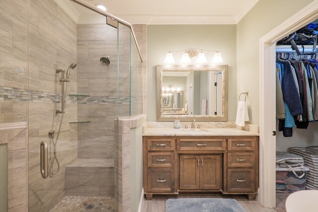 bathroom featuring crown molding, a shower with door, vanity, and hardwood / wood-style floors