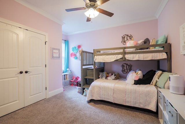 carpeted bedroom with ceiling fan, crown molding, and a closet