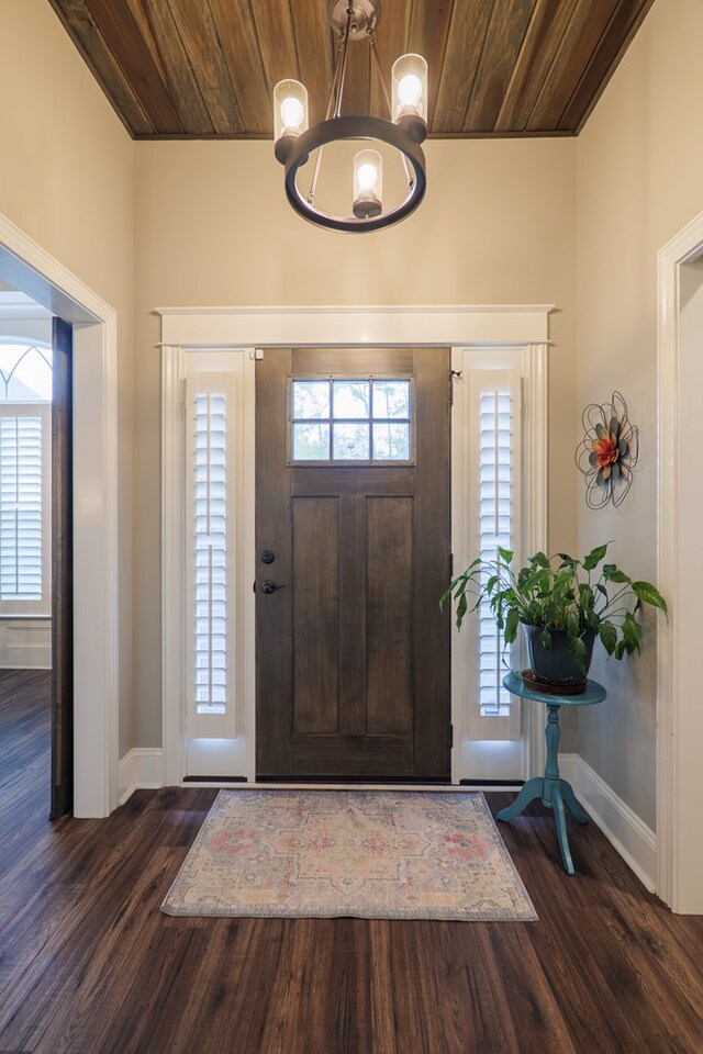 entryway with dark hardwood / wood-style flooring and wood ceiling