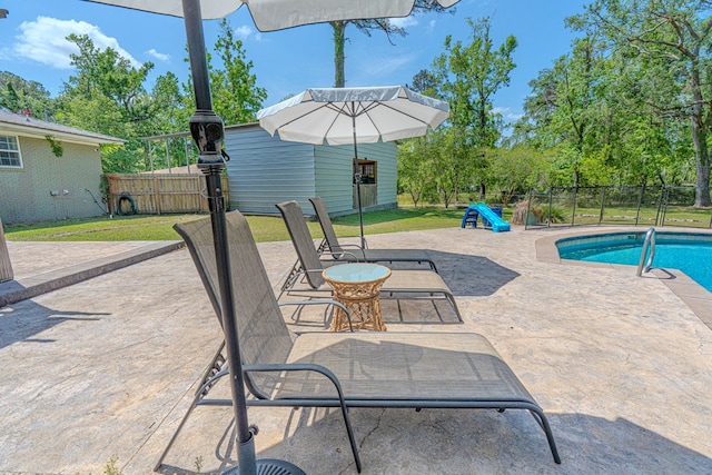 view of patio featuring fence, an outbuilding, and a fenced in pool