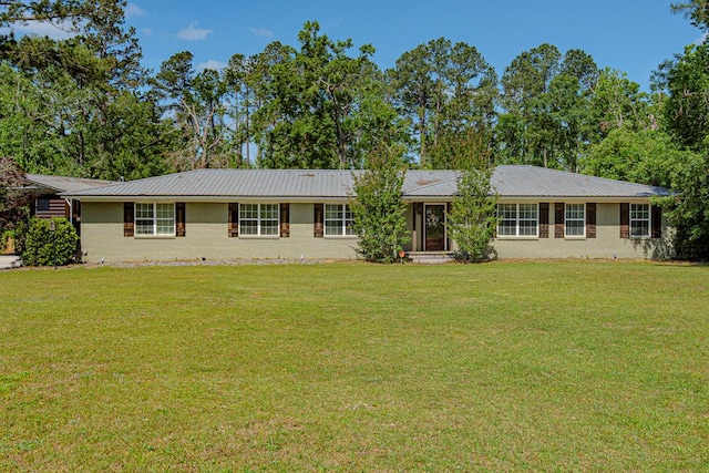 ranch-style house featuring brick siding, a front lawn, and metal roof