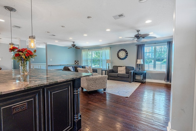 living area with crown molding, a ceiling fan, dark wood-type flooring, and visible vents