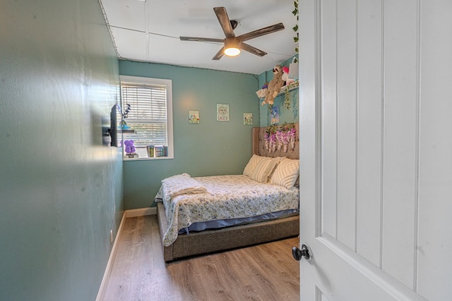 bedroom featuring baseboards, a ceiling fan, and wood finished floors
