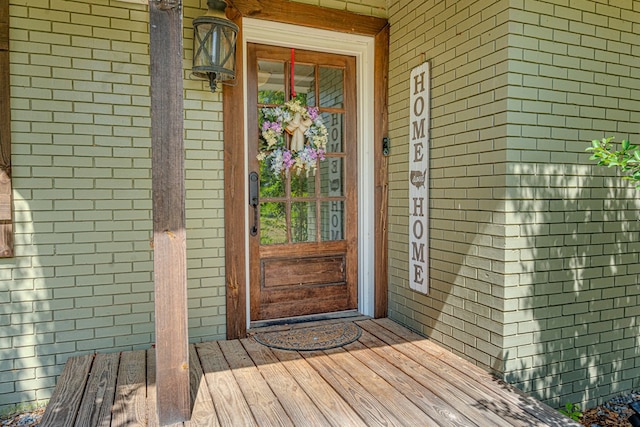 doorway to property featuring brick siding
