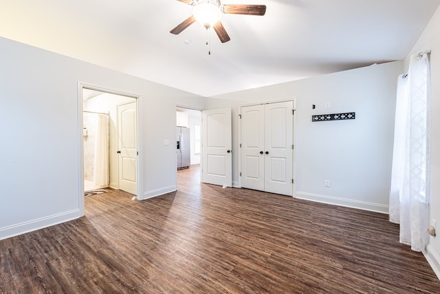 unfurnished bedroom with ceiling fan, stainless steel fridge with ice dispenser, and dark wood-type flooring