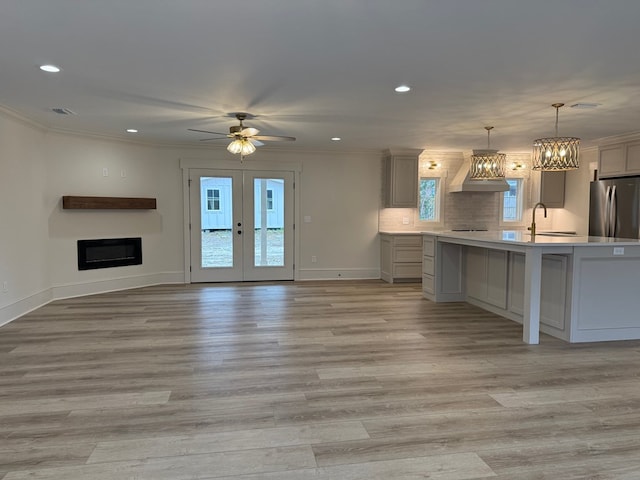 kitchen featuring ornamental molding, stainless steel fridge, decorative light fixtures, and gray cabinets