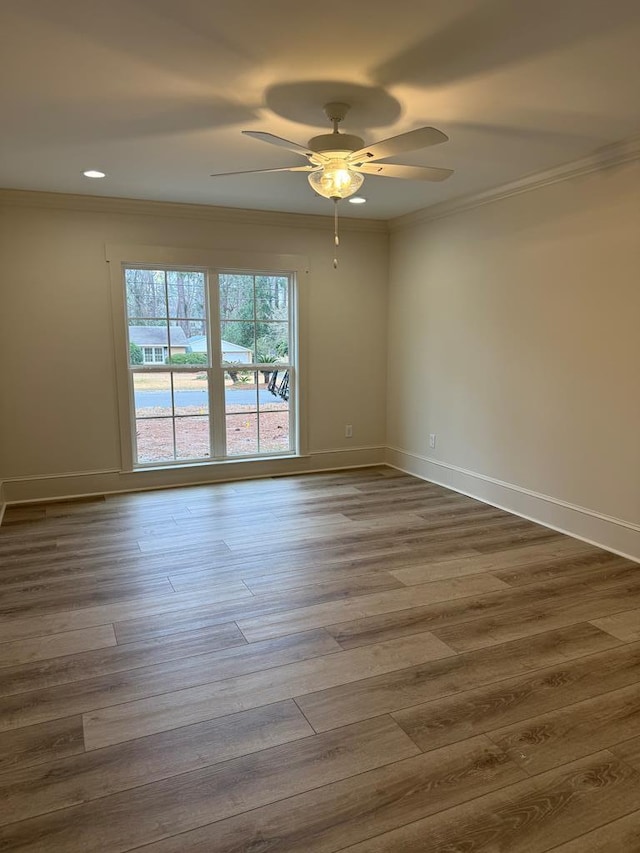 empty room with hardwood / wood-style floors, crown molding, and ceiling fan