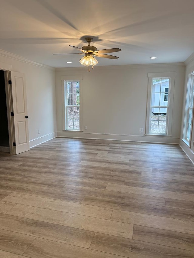 empty room with light hardwood / wood-style flooring, ornamental molding, and ceiling fan