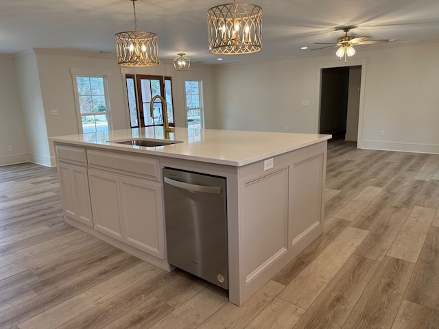 kitchen featuring sink, a kitchen island with sink, white cabinetry, ornamental molding, and light hardwood / wood-style floors