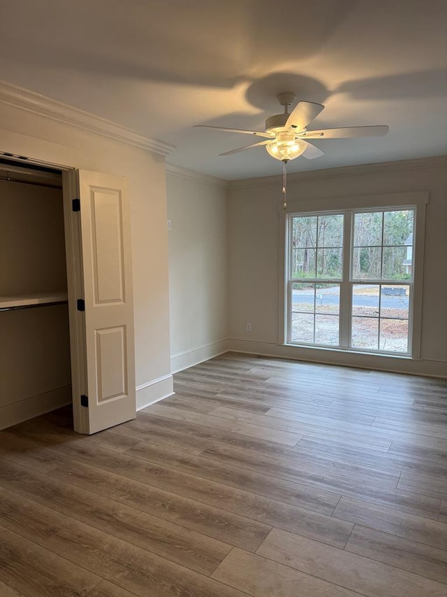 unfurnished bedroom featuring ornamental molding, ceiling fan, and light wood-type flooring