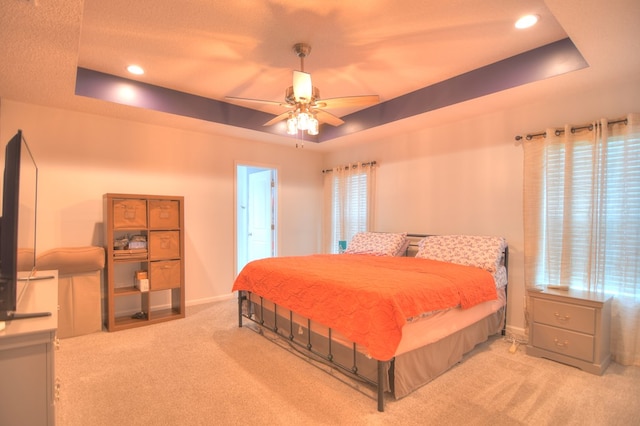 carpeted bedroom featuring recessed lighting, baseboards, a raised ceiling, and a ceiling fan