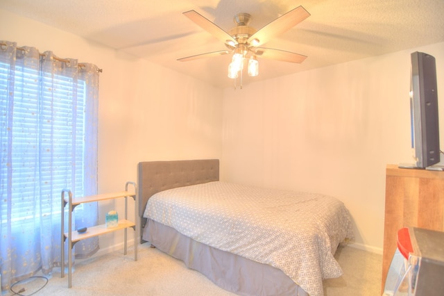 carpeted bedroom with baseboards, a textured ceiling, and ceiling fan