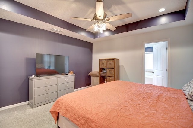 bedroom featuring a tray ceiling, recessed lighting, carpet, baseboards, and ceiling fan