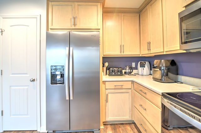 kitchen featuring light wood-type flooring, stainless steel appliances, light brown cabinetry, and light countertops