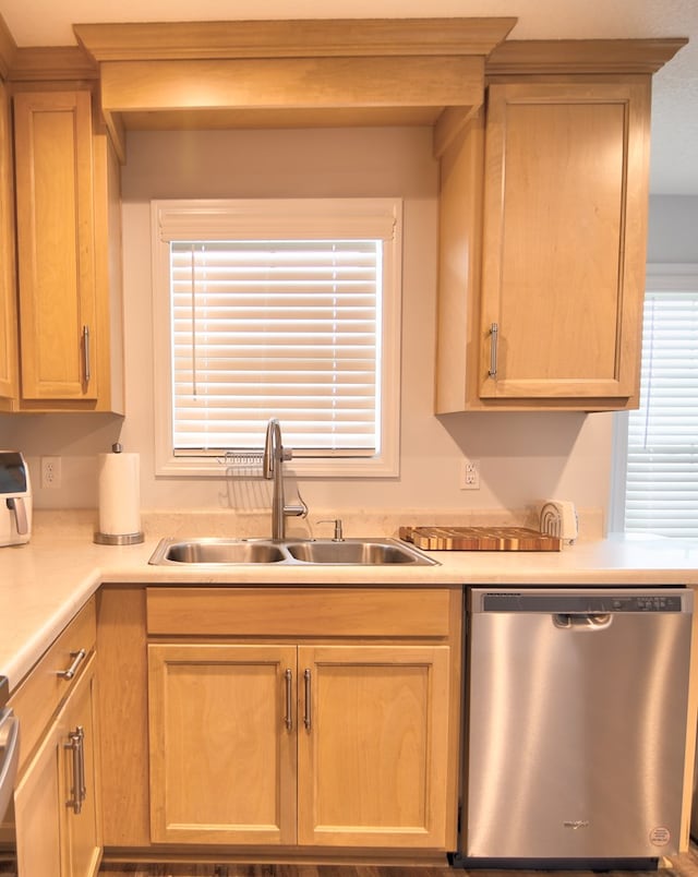 kitchen with a sink, dishwasher, light brown cabinetry, and light countertops