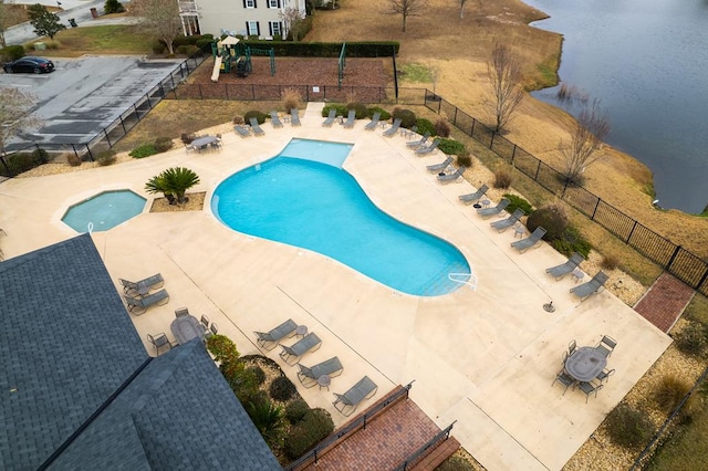 view of pool featuring a water view, a playground, and a patio