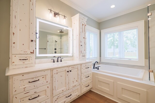 bathroom featuring hardwood / wood-style flooring, plus walk in shower, vanity, and crown molding