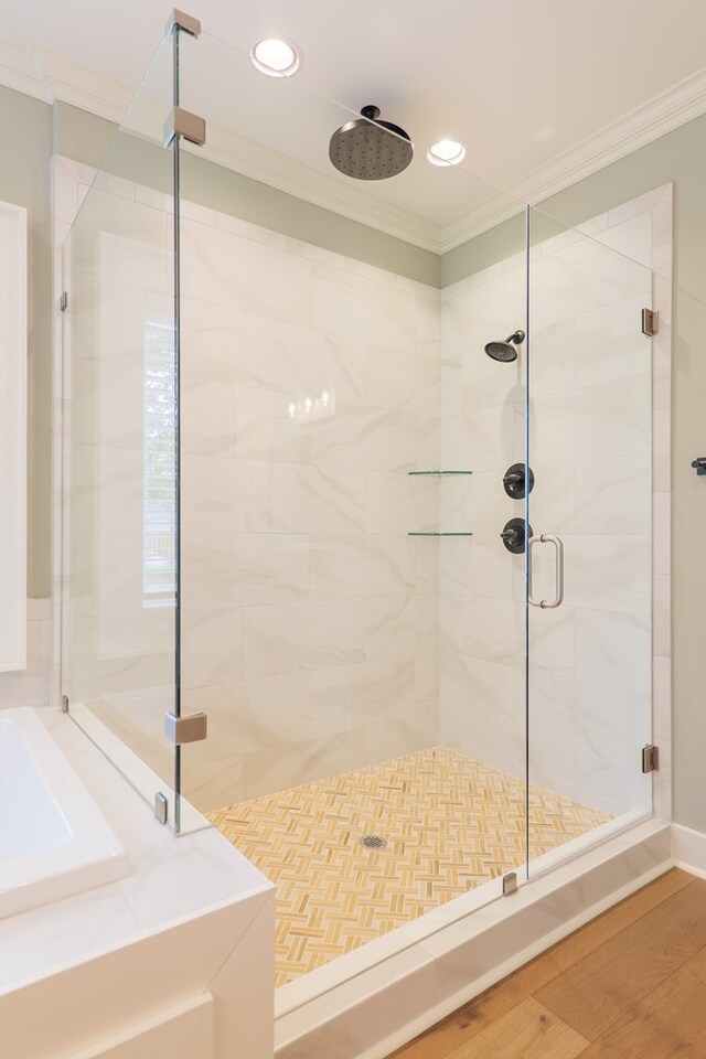 bathroom featuring a shower with shower door, ornamental molding, and wood-type flooring