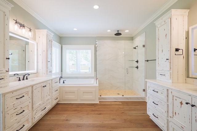 bathroom featuring crown molding, separate shower and tub, hardwood / wood-style floors, and vanity