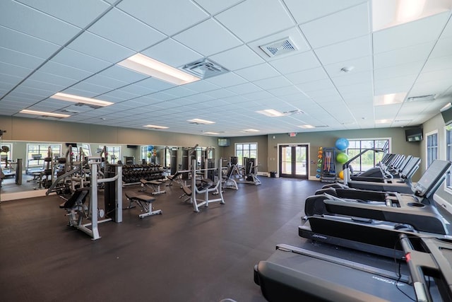 workout area with a paneled ceiling and french doors