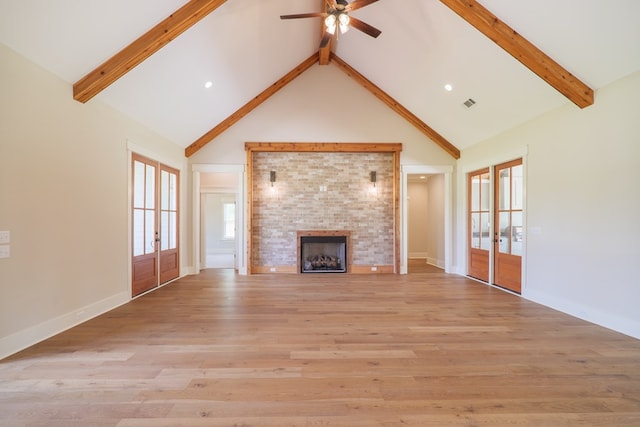 unfurnished living room with french doors, light hardwood / wood-style floors, and beamed ceiling