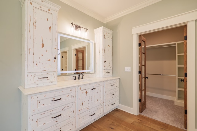 bathroom with ornamental molding, hardwood / wood-style floors, and vanity