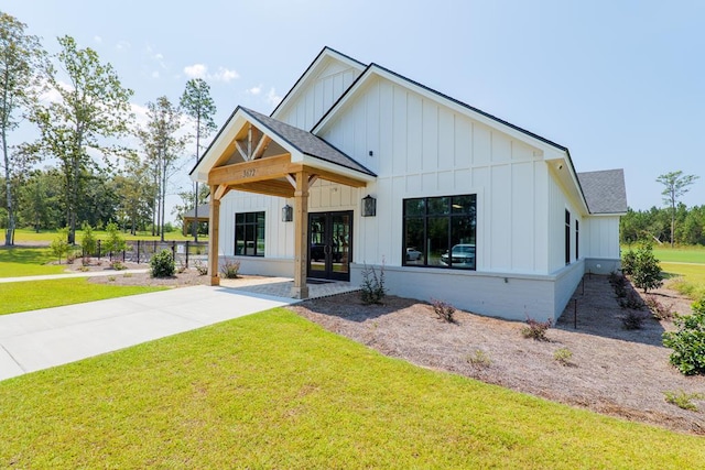 view of front of property featuring a front yard and french doors