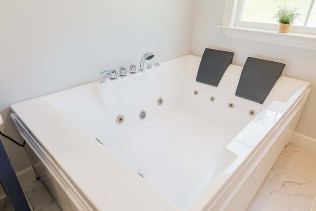 4310 Old Quitman Hwy, Valdosta, GA 31601 - bathroom featuring marble look tiles, a jetted tub, and baseboards