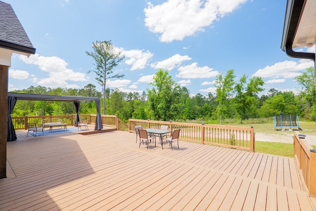 4310 Old Quitman Hwy, Valdosta, GA 31601 - wooden deck featuring a trampoline, outdoor dining space, and a yard