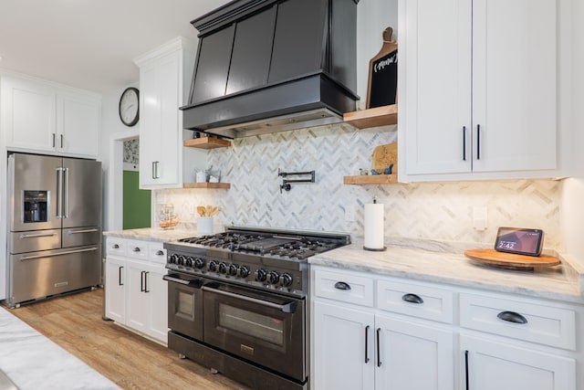 4310 Old Quitman Hwy, Valdosta, GA 31601 - kitchen featuring premium appliances, custom exhaust hood, open shelves, white cabinets, and light wood-style floors