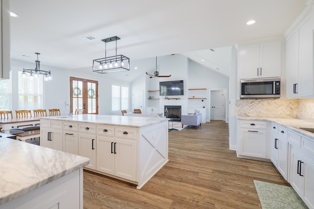 4310 Old Quitman Hwy, Valdosta, GA 31601 - kitchen featuring stainless steel microwave, ceiling fan, a fireplace, lofted ceiling, and recessed lighting