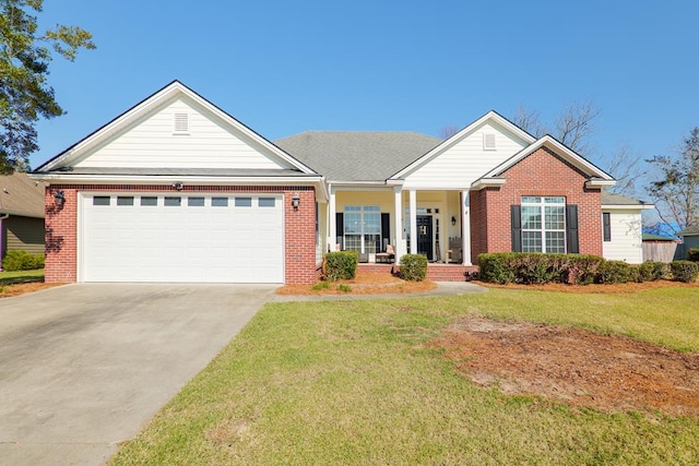 view of front of home featuring covered porch, a garage, and a front lawn