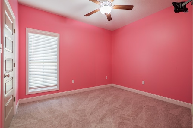 carpeted empty room featuring baseboards and a ceiling fan